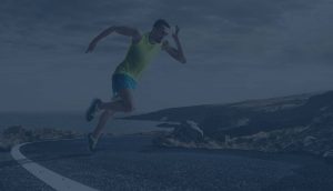 photo of man running by the ocean on asphalt pavement